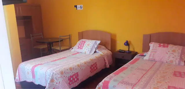 Habitación doble con dos camas y mesa