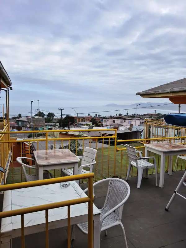Mesas de la terraza con barandas amarillas y vista al mar